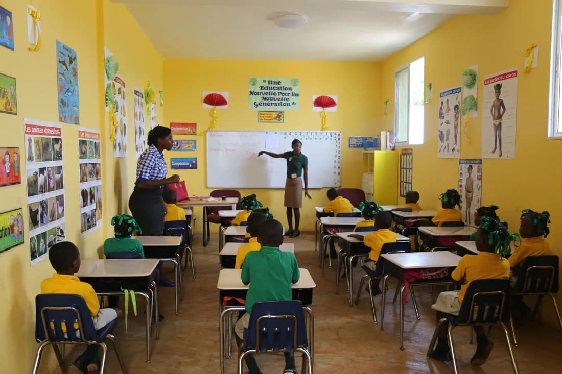 Students learning together in a bright yellow classroom at BATI